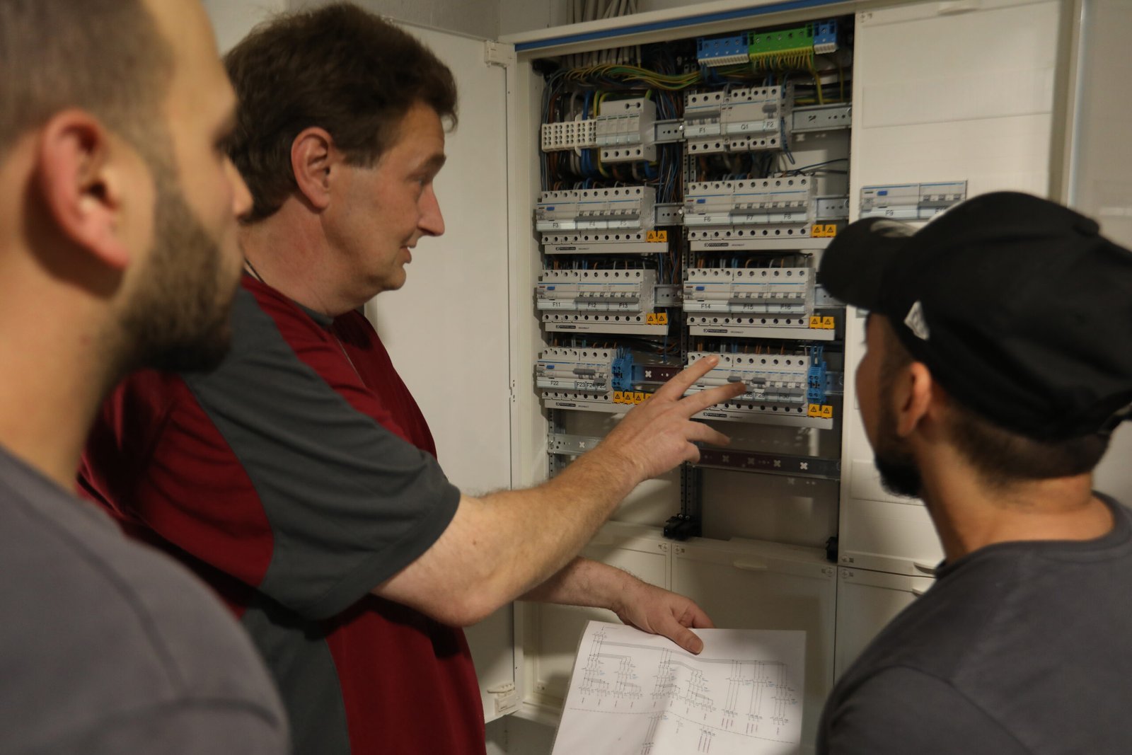 Personen vor einem Sicherungskasten